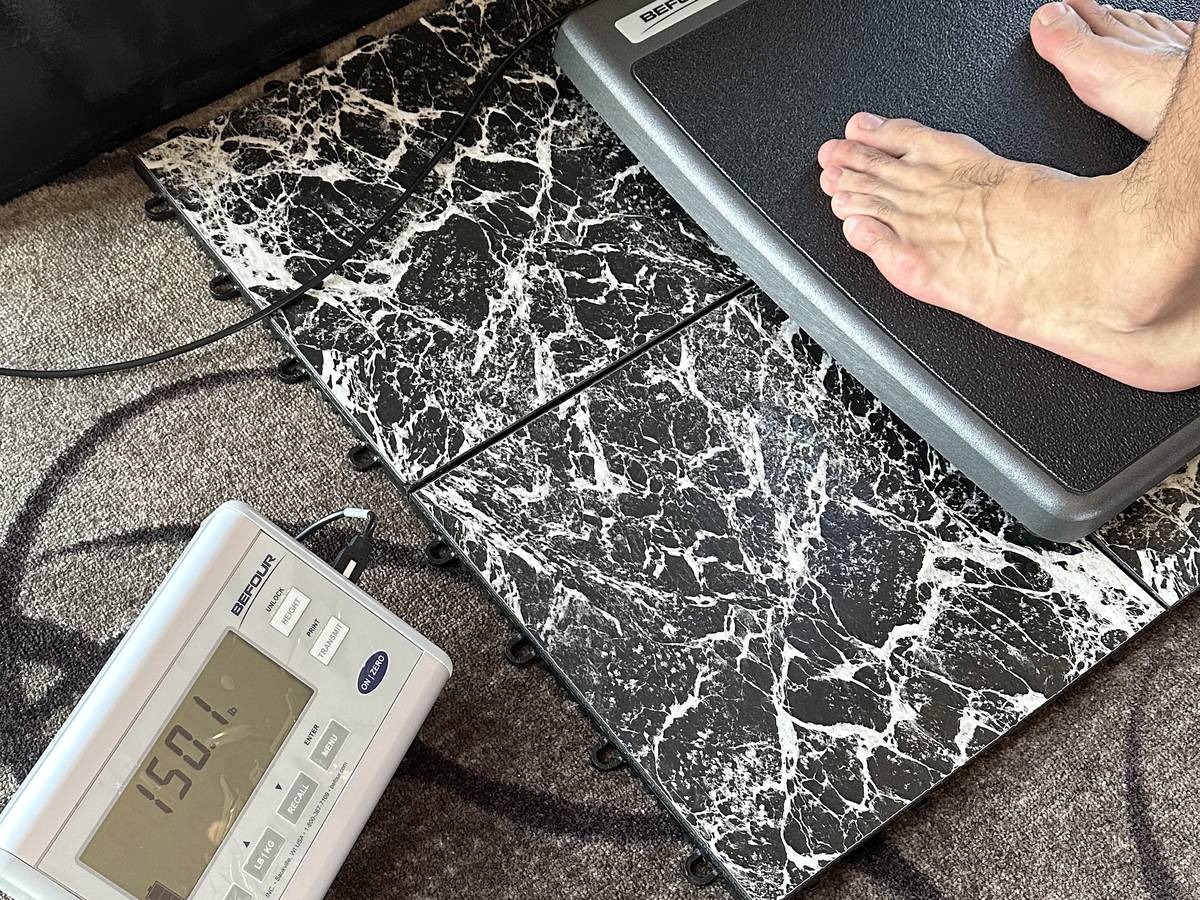 Digital platform scale reading 150.1 lb during a weight check