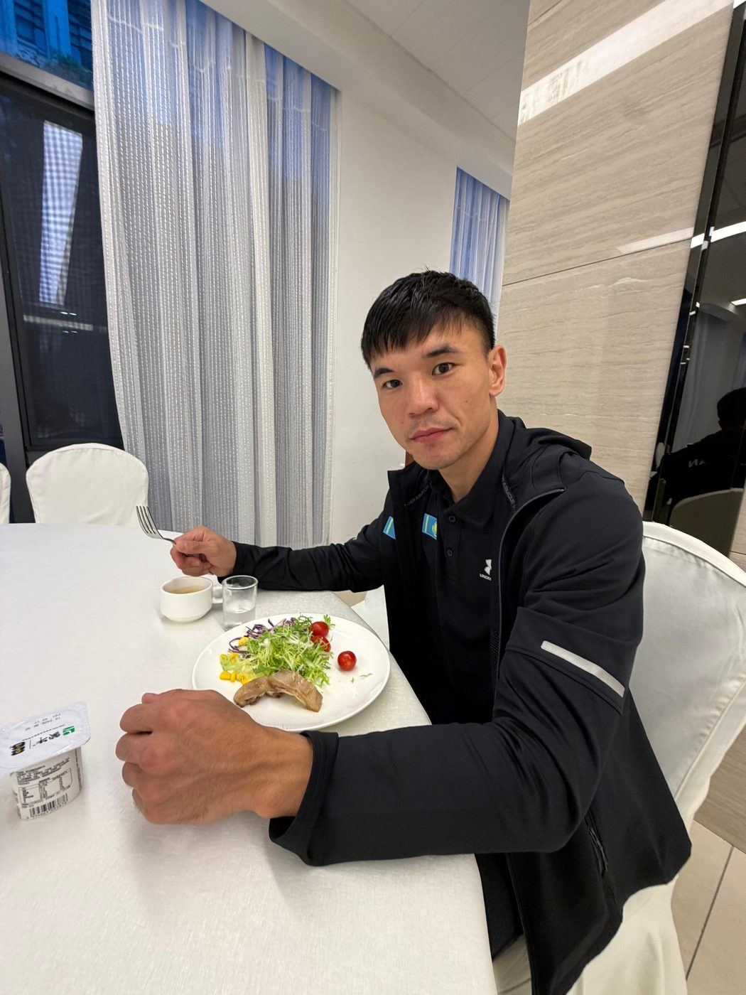 Ablaikhan Zhussupov eating a measured camp meal in Kazakhstan national team kit